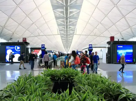 Spacious airport interior with high ceilings and directional signage for gates 20 and 21.