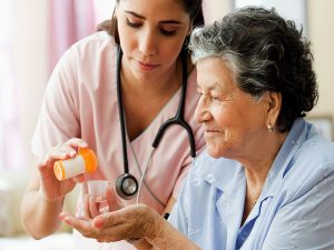 in-home caregivers assisting a patient A nurse giving medicine to a patient